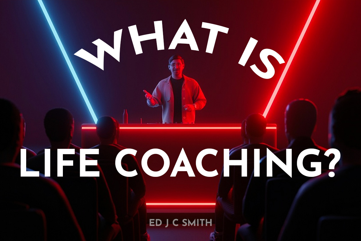 A presenter on stage under vibrant red and blue lighting, speaking to an audience about life coaching. The text overlay reads, "What Is Life Coaching?" with "Ed J C Smith" at the bottom.
